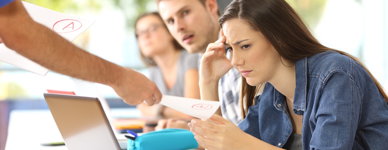 Unhappy student receiving a bad grade in classroom