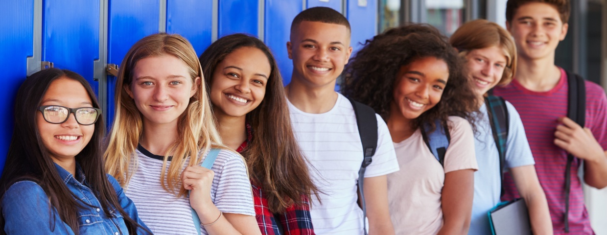 students smiling with backpacks